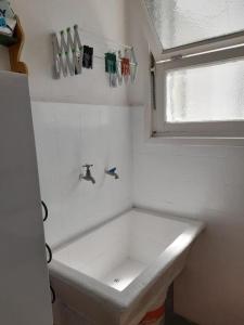 een kleine badkamer met een wastafel en een raam bij depto 6 personas en costa argentina in Miramar