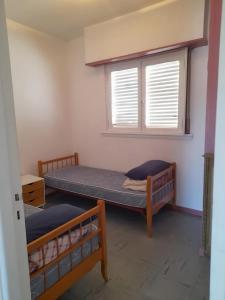 2 stapelbedden in een kamer met een raam bij depto 6 personas en costa argentina in Miramar