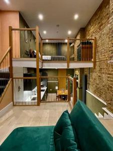 a living room with a green couch and a brick wall at Exposed Brick Flat Finsbury Park in London