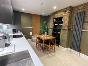 a kitchen with a wooden table in a kitchen at Exposed Brick Flat Finsbury Park in London