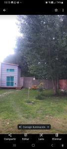 a yard with a house and a fence and a tree at Sur tiny house in El Bolsón