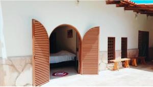 a bedroom with three wooden arches in a room at Fazenda Araras Pirenópolis in Pirenópolis