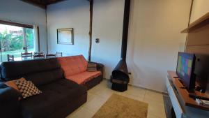 uma sala de estar com um sofá e uma lareira em Rancho dos Mantas em Santo Antônio do Pinhal