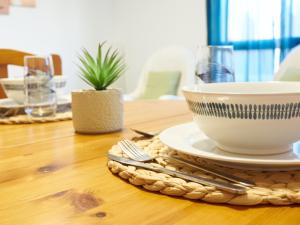 a wooden table with a bowl and a plate on it at EL RINCÓN VERDE in Puerto de Sagunto