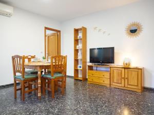 a dining room with a table and a television at EL RINCÓN VERDE in Puerto de Sagunto