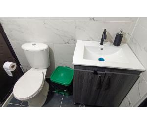 y baño con lavabo blanco y aseo. en Hermosa vivienda central en el mejor lugar de Medellín en Envigado