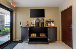 un carrello di cibo in una stanza con una televisione appesa a un muro di Extended Stay America Suites - Fort Lauderdale - Cypress Creek - Andrews Ave a Fort Lauderdale