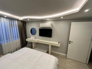 a bedroom with a bed and a desk with a tv at ISTANBUL SUITE in Istanbul