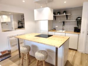 una cocina con una isla de cocina con 2 taburetes en Apartamento Marcos, en Villanúa