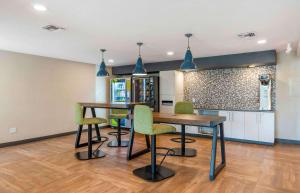 una cocina con 2 mesas y sillas verdes en Extended Stay America Premier Suites - Fort Lauderdale - Cypress Creek - Park North, en Pompano Beach