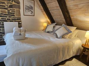 a bedroom with a white bed with a chair at DATCHA ANASTASIA in Besse-et-Saint-Anastaise