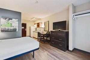 a hotel room with a bed and a flat screen tv at Extended Stay America Suites - Miami - Airport - Doral in Miami