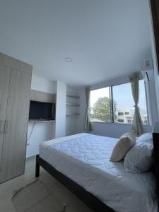 a bedroom with a bed and a large window at Playa el Mansito Apartamento Ocean Sun in Punta Blanca