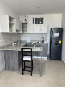 a kitchen with a table and a black refrigerator at Playa el Mansito Apartamento Ocean Sun in Punta Blanca