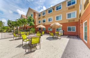 un patio con mesas y sillas y un edificio en Extended Stay America Premier Suites - Miami - Airport - Miami Springs, en Miami