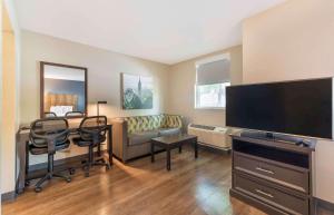 Extended Stay America Premier Suites - Miami - Airport - Doral - 25th Street في ميامي: غرفة معيشة مع تلفزيون بشاشة مسطحة كبيرة