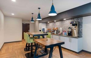 a kitchen with two tables and chairs in a room at Extended Stay America Premier Suites - Miami - Coral Gables in Miami