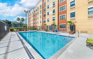 a swimming pool in front of a building at Extended Stay America Premier Suites - Miami - Airport - Doral - 25th Street in Miami