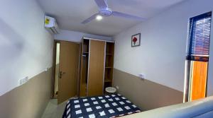 Cette chambre comprend un lit et un ventilateur de plafond. dans l'établissement Wisdom Villa, à Kumasi