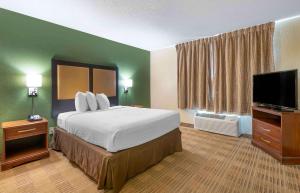 a hotel room with a bed and a flat screen tv at Extended Stay America Suites - West Palm Beach - Northpoint Corporate Park in West Palm Beach