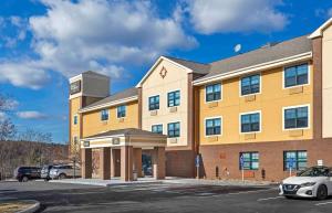 a large yellow building with a parking lot at Extended Stay America Suites - Boston - Braintree in Braintree