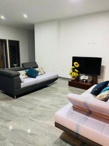 een woonkamer met 2 banken en een flatscreen-tv bij Apartamento familiar NaturalSuite in Puyo