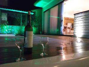 una botella de vino y dos copas de vino en una mesa en Morada do sol, en Arraial do Cabo