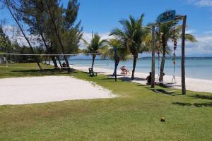 una playa con palmeras y una red de voleibol en Morada do sol, en Arraial do Cabo