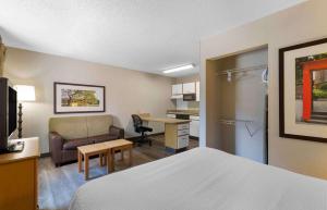 a hotel room with a bed and a couch and a desk at Extended Stay America Suites - Boston - Peabody in Peabody
