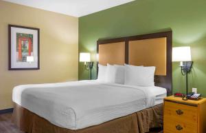 a large bed in a hotel room with two lamps at Extended Stay America Suites - Boston - Waltham - 32 4th Ave in Waltham