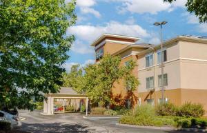 a building with a parking lot in front of it at Extended Stay America Suites - Boston - Waltham - 52 4th Ave in Waltham