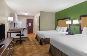 a hotel room with two beds and a desk at Extended Stay America Suites - Boston - Westborough - Connector Road in Westborough