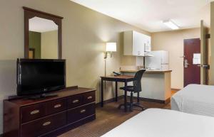 a hotel room with a bed and a desk with a television at Extended Stay America Suites - Boston - Westborough - Connector Road in Westborough