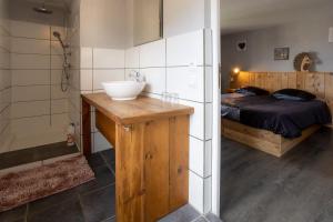 CHAMBRE D'HOTE في Granges-sur-Vologne: حمام مع حوض وسرير ودوش