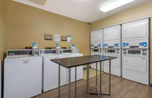 a laundry room with washers and dryers and a table at Extended Stay America Suites - Hanover - Parsippany in Whippany
