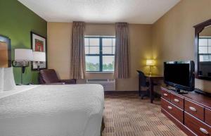 um quarto de hotel com uma cama e uma televisão de ecrã plano em Extended Stay America Suites - Edison - Raritan Center em Edison