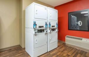 Habitación con nevera blanca y paredes rojas. en Extended Stay America Suites - Meadowlands - Rutherford, en Rutherford