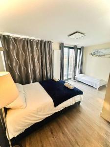 a bedroom with a bed in a room with wooden floors at Luxurious 2 Bedroom flat in Central London in London
