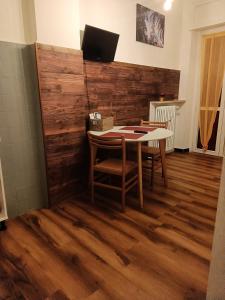 a table and chairs in a room with a wooden wall at MountainAosta - CIR 0062 in Aosta