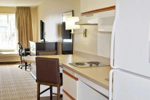 cocina con nevera y mesa con sillas en Extended Stay America Suites - Meadowlands - East Rutherford, en East Rutherford