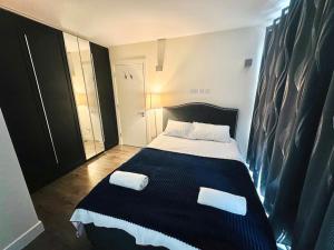 a bedroom with a bed with two towels on it at Luxurious 2 Bedroom flat in Central London in London