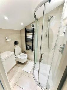 a bathroom with a toilet and a glass shower at Luxurious 2 Bedroom flat in Central London in London