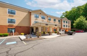 a building with a car parked in a parking lot at Extended Stay America Suites - Ramsey - Upper Saddle River in Ramsey