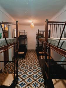 a room with three bunk beds and a tiled floor at Mask Off Artel in Essaouira
