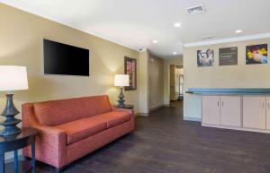 a living room with a couch and a flat screen tv at Extended Stay America Suites - Hartford - Farmington in Farmington