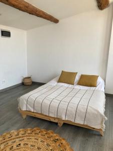 a bedroom with a bed with white walls and a rug at La Maison sur les Toits in Aix-en-Provence