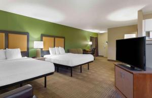 a hotel room with two beds and a flat screen tv at Extended Stay America Suites - Hartford - Farmington in Farmington