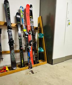 a bunch of skis are lined up against a wall at DOLOMITI HOUSE 9 in Fiera di Primiero