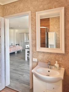 ein Bad mit einem Waschbecken und einem Spiegel in der Unterkunft Apartamenty Nexo in Neksø