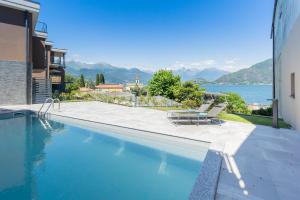 a swimming pool with chairs and a view of the water at ANNA'S LODGE QUITE & CHARME in Pianello Del Lario